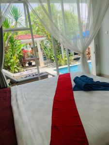 a bedroom with a bed with a red stripe on it at Villa WENHOMANN in Lovina +32 photos