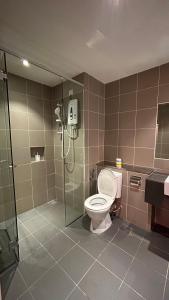 a bathroom with a toilet and a glass shower stall at Aeropod Sovo for 5 pax in Kota Kinabalu