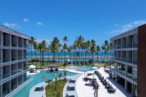ein Resort mit einem Pool mit Palmen und dem Meer in der Unterkunft Porto alto resort in Ipojuca