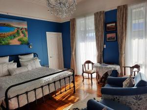 una camera da letto con pareti blu e un letto e sedie di Mariner Rose B&B a Stanley