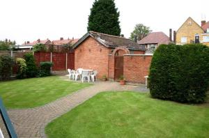 een terras met een tafel en stoelen in een tuin bij Kinda Apartments in Skegness