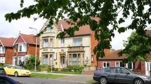 een huis met auto's ervoor geparkeerd bij Kinda Apartments in Skegness