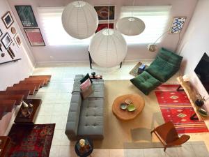 een woonkamer met een bank en een tafel bij Descubra a Casa Felicidade em Belém! Climatizada, com sala ampla, 2 quartos, mezanino e Wi-Fi veloz. Localização central perto de atrações e gastronomia. Viva a Amazônia com conforto exclusivo. Reserve já sua experiência inesquecível! in Curro Velho