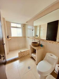a bathroom with a toilet and a sink and a shower at Alberca privada, vista al mar, frente playa foro boca in Boca del Río +47 photos