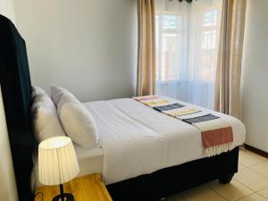 a bedroom with a large bed with a window at Mon-Est Self service Apartment in Gaborone