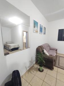 a living room with a couch and a mirror at Ap SOL in Piracicaba