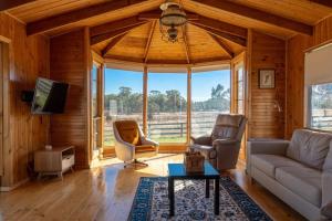 Quarry HillにあるThe Family Farmhouseのソファと椅子、大きな窓のあるリビングルーム