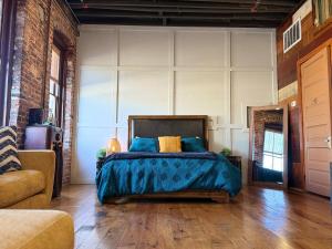 a bedroom with a bed with blue pillows on it at Exposed Elegance in Mobile