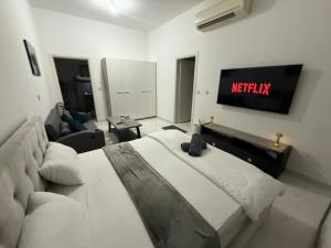 une chambre avec un lit et une télévision au mur dans l'établissement Brand new Stylish Studio Near to Yas & Airport, à Abu Dhabi