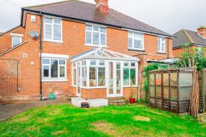 a brick house with a greenhouse in the yard at Luccombe Lodge in Southampton