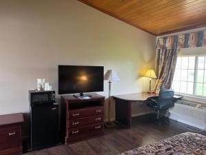 a bedroom with a desk with a computer and a bed at Town & Country Motel in Clinton +11 photos