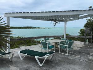 un patio avec une table et des chaises et l'océan dans l'établissement Sunset Cabin, à Twin Lakes
