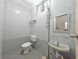 a white bathroom with a toilet and a sink at Kluang Budget Home in Kluang