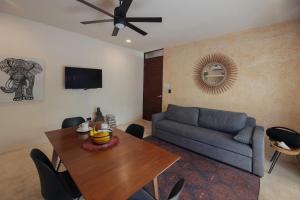 een woonkamer met een blauwe bank en een tafel bij Charming Tulum Getaway in Prime Location in Tulum