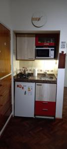a kitchen with a stove and a microwave at Departamento Monoambiente Centro Villa Carlos Paz in Villa Carlos Paz