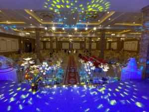 a large banquet hall with blue lights and flowers at An Thái Hotel in Kon Tum