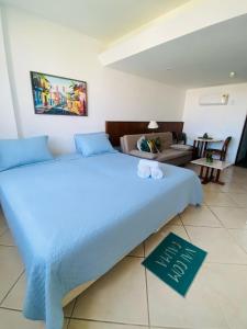 a large blue bed in a room with a couch at Hotel sol vitória Marina in Salvador
