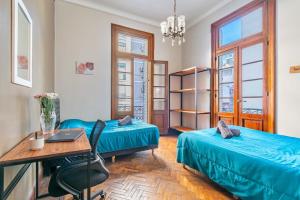 a room with two beds and a desk and a table at Luxury mansion in Recoleta - Jacuzzi - Sauna - 40 people in Buenos Aires