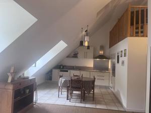 科特雷Appartement spacieux au centre de Cauterets, 6 pers., skis et parking - FR-1-812-46的房间里有一张桌子和几把椅子的厨房