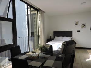 a bedroom with a bed and a table and chairs at EON Urban Loft Ciudad de Guatemala in Estación Pamplona +20 photos