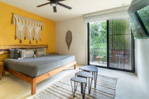 een slaapkamer met een bed en krukken. bij Charming Tulum Getaway in Prime Location in Tulum +27 foto's