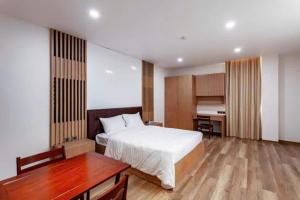 a hotel room with a bed and a desk and a desk at Thúy Apartment Hải Phòng in Hai Phong