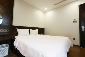 a bedroom with a large white bed with white sheets at Thúy Apartment Hải Phòng in Hai Phong