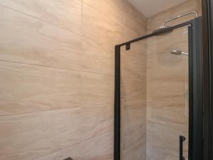 a shower with a glass door in a bathroom at Top Holme Cottage in York +17 photos