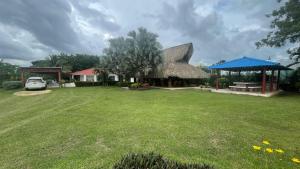a house with a thatched roof and a yard at Hacienda Villa Hermelina-Casa Campestre in Turbaco