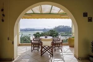 a dining room with a table and chairs and a large window at Blue Coast Suites - Seaside Retreat with Pool in Exclusive Kommeno in Kommeno +34 photos
