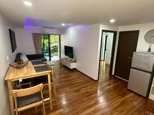 cocina y sala de estar con mesa y nevera en Apartment Title III Rawai Phuket, en Rawai Beach