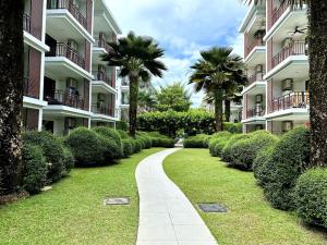 una pasarela frente a un edificio con palmeras en Apartment Title III Rawai Phuket, en Rawai Beach