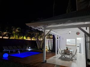 a patio at night with a table and chairs at Villa SAINT BARTHELEMY in Saint-François +2 photos