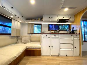 a small room with a bed and a kitchen in a trailer at Vintage Coral Pink in Nelly Bay