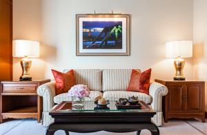 a living room with a couch and a coffee table at The Peninsula Bangkok in Bangkok