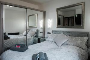 a bedroom with two beds and a mirror on the wall at The Residence in Kendal