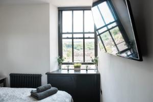 a bedroom with a bed and a large window at The Residence in Kendal