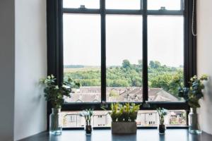 a window with flowers in vases on a table at The Residence in Kendal