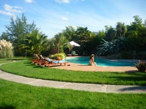 a woman sitting next to a swimming pool at Hotel Boutique Solaz Bella Vista de Colchagua in Santa Cruz