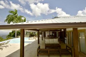 a house with a metal roof and a swimming pool at Villa Lukner Las Terrenas in Las Terrenas