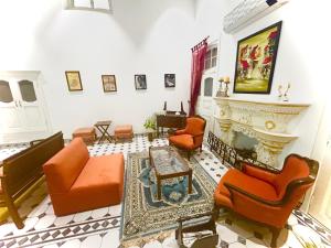 a living room with orange chairs and a fireplace at Grand Villa in Amritsar