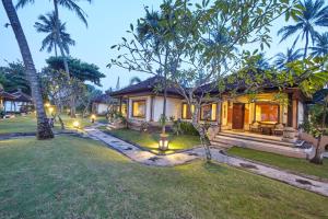 ein Haus mit einem Garten davor in der Unterkunft Puri Bagus Candidasa in Candidasa
