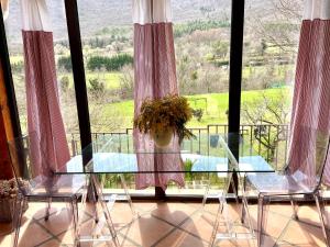 two chairs and a glass table in front of a window at DOMAINE St GEORGES in Mosset