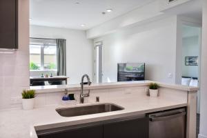 - une cuisine avec un évier et un grand miroir dans l'établissement Bright & Stylish 1-Bedroom, Walk to Netflix, Perfect for Long Stays FREE PARKING, à Los Angeles 25 autres photos