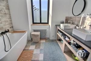 a bathroom with a tub and a sink and a mirror at La marie morgane in Lézardrieux +39 photos