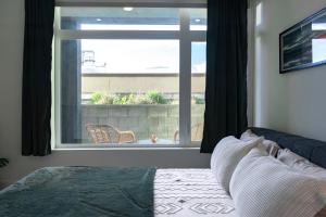 une chambre avec un lit et une grande fenêtre dans l'établissement Bright & Stylish 1-Bedroom, Walk to Netflix, Perfect for Long Stays FREE PARKING, à Los Angeles