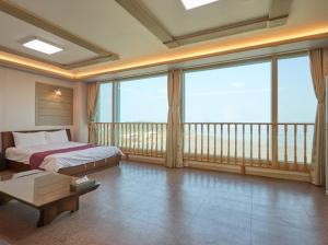 a bedroom with a bed and a balcony with windows at RESTHE hotel in Incheon +13 photos