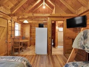 una stanza con un frigorifero e un tavolo in una cabina di Cozy Cabin with Breathtaking Views near Dollywood a Pigeon Forge