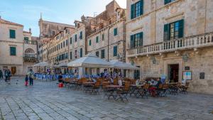 a group of people sitting at tables in a street at Apartments Petra in Dubrovnik