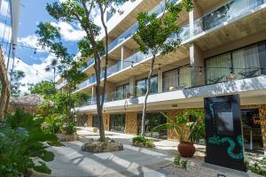 an external view of a building with trees in the courtyard at TUK Tulum Studios in Tulum